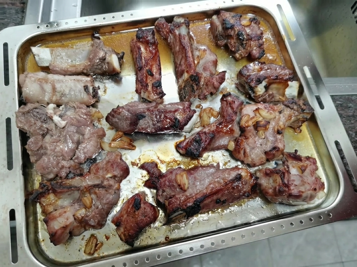 Travers de porc rôtis et caramélisés reposant sur une plaque de cuisson.