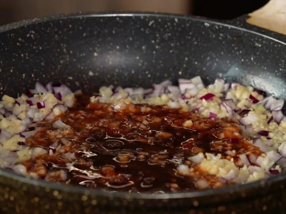 Ingrédients liquides de la sauce et pommes en dés mijotant dans une poêle.