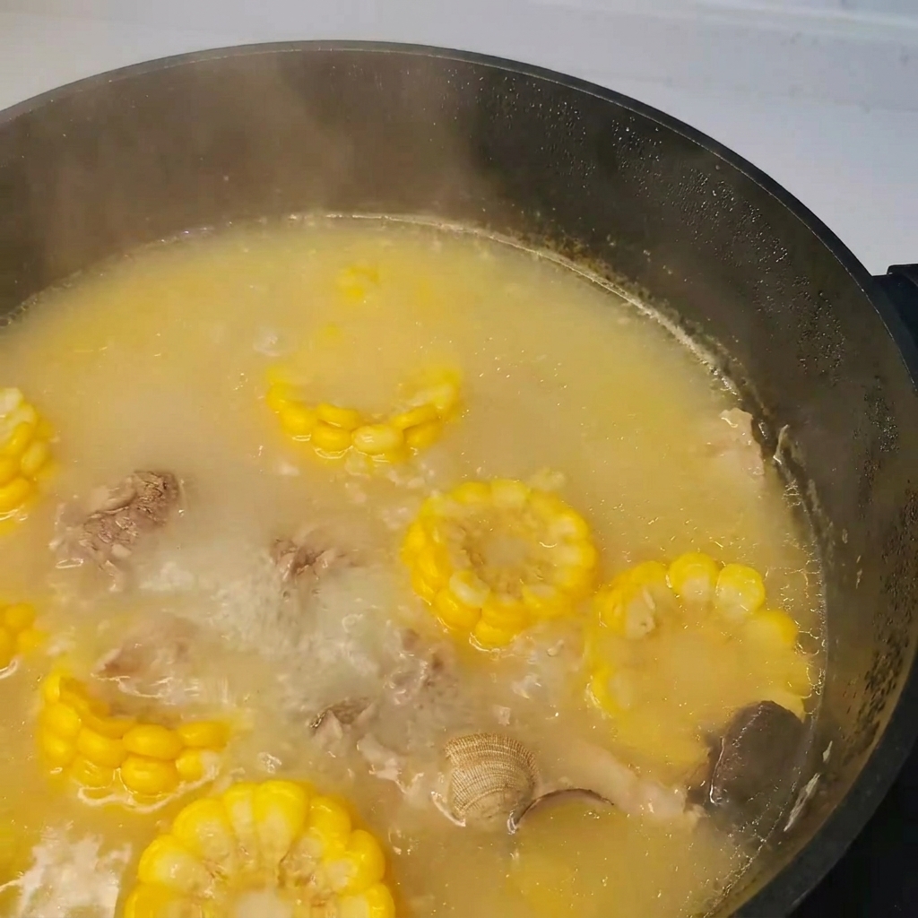 Algues (kombu) ajoutées à la casserole de soupe bouillante au porc, aux palourdes et aux légumes.