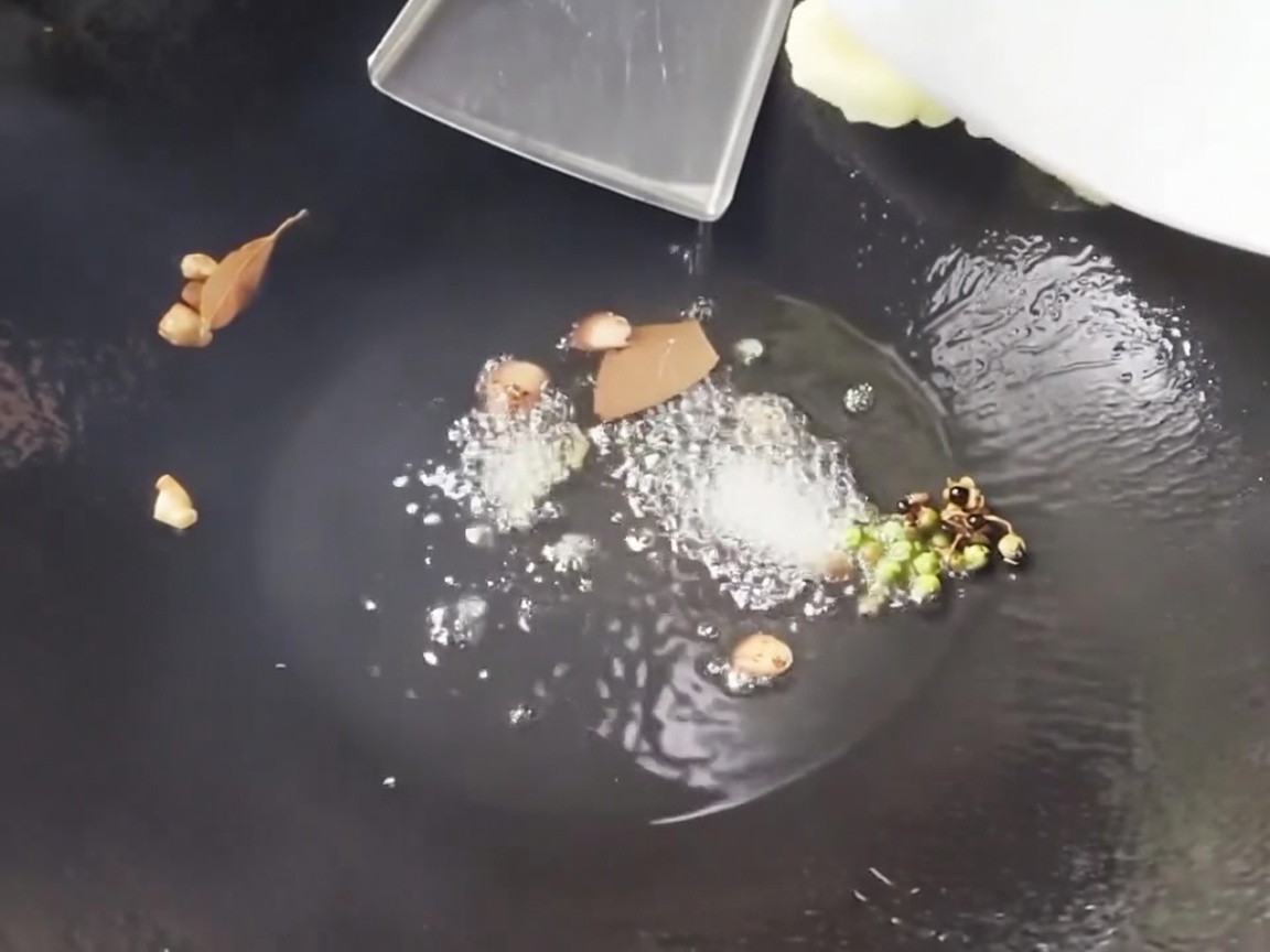 Pousses de bambou et maïs en tranches sautés dans un wok chaud avec des aromates.