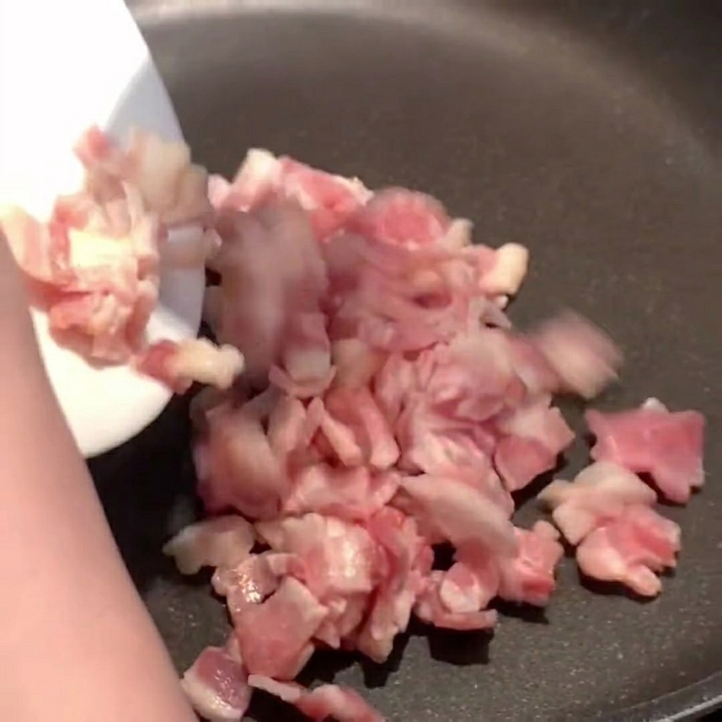 Lardons qui dorent dans une poêle chaude, libérant leur gras.