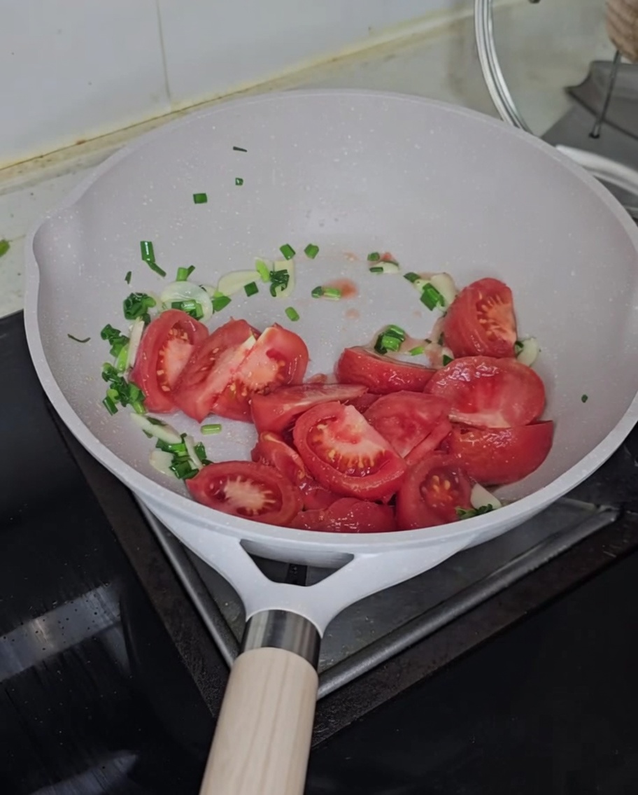 Tomates en dés ajoutées à la poêle avec les aromates.