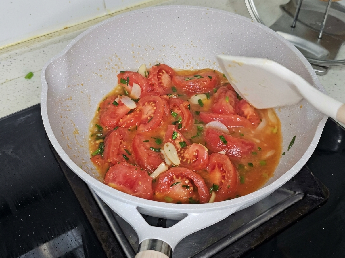 Eau bouillante versée dans la poêle sur les tomates sautées.
