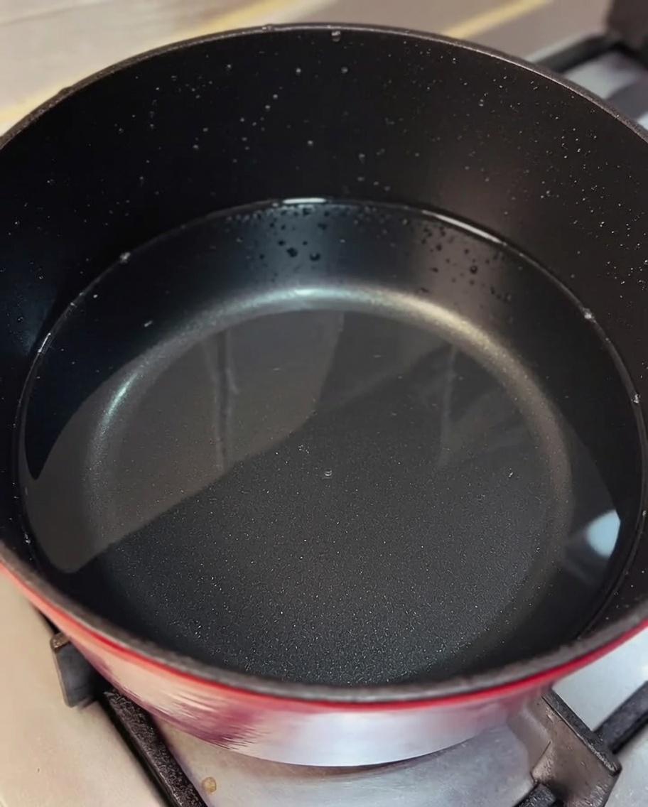 Poulet effiloché incorporé dans une casserole de bouillon frémissant.