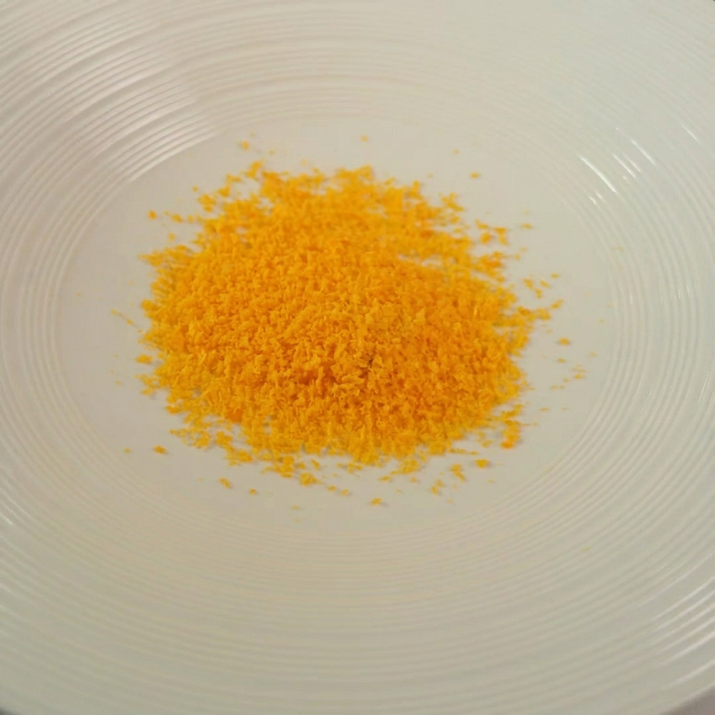 Un bol contenant un mélange doré de chapelure, dherbes et de parmesan râpé.