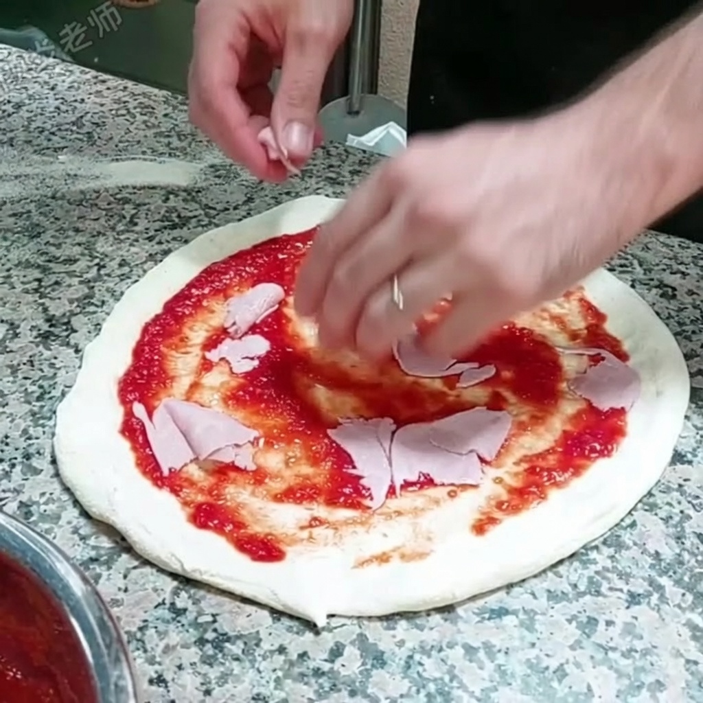 Des tranches fines de jambon déposées sur la base de pizza recouverte de sauce tomate.