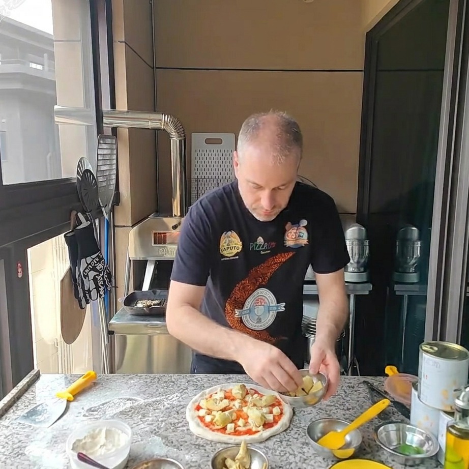 Morceaux de cœurs dartichauts en conserve placés sur la pizza recouverte de fromage.