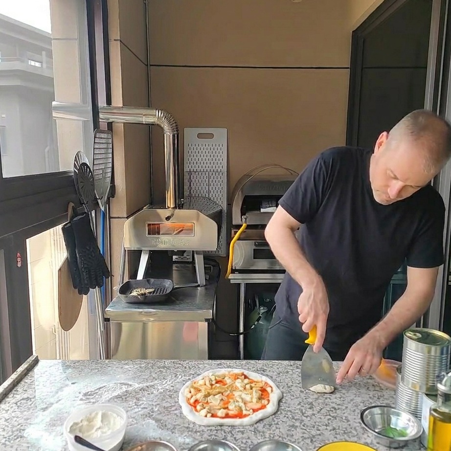 Morceaux de poulet grillé disposés sur la pizza aux artichauts et au fromage.