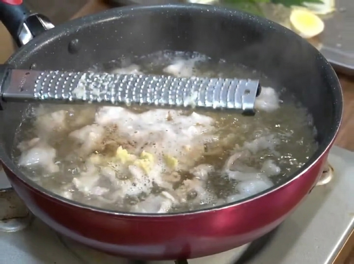 Ail et gingembre finement râpés ajoutés au bouillon frémissant.