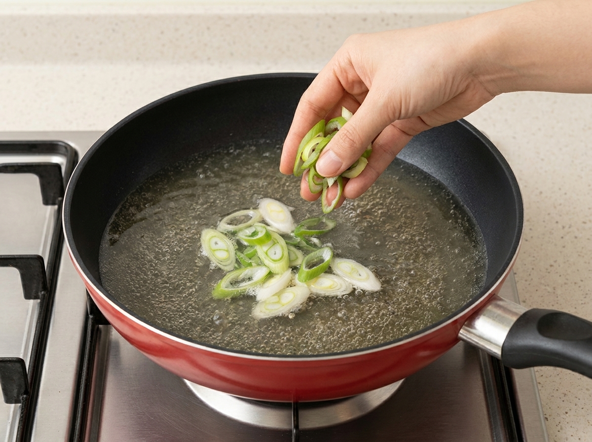 Oignons longs tranchés et pousses de soja ajoutés à la soupe ramen.