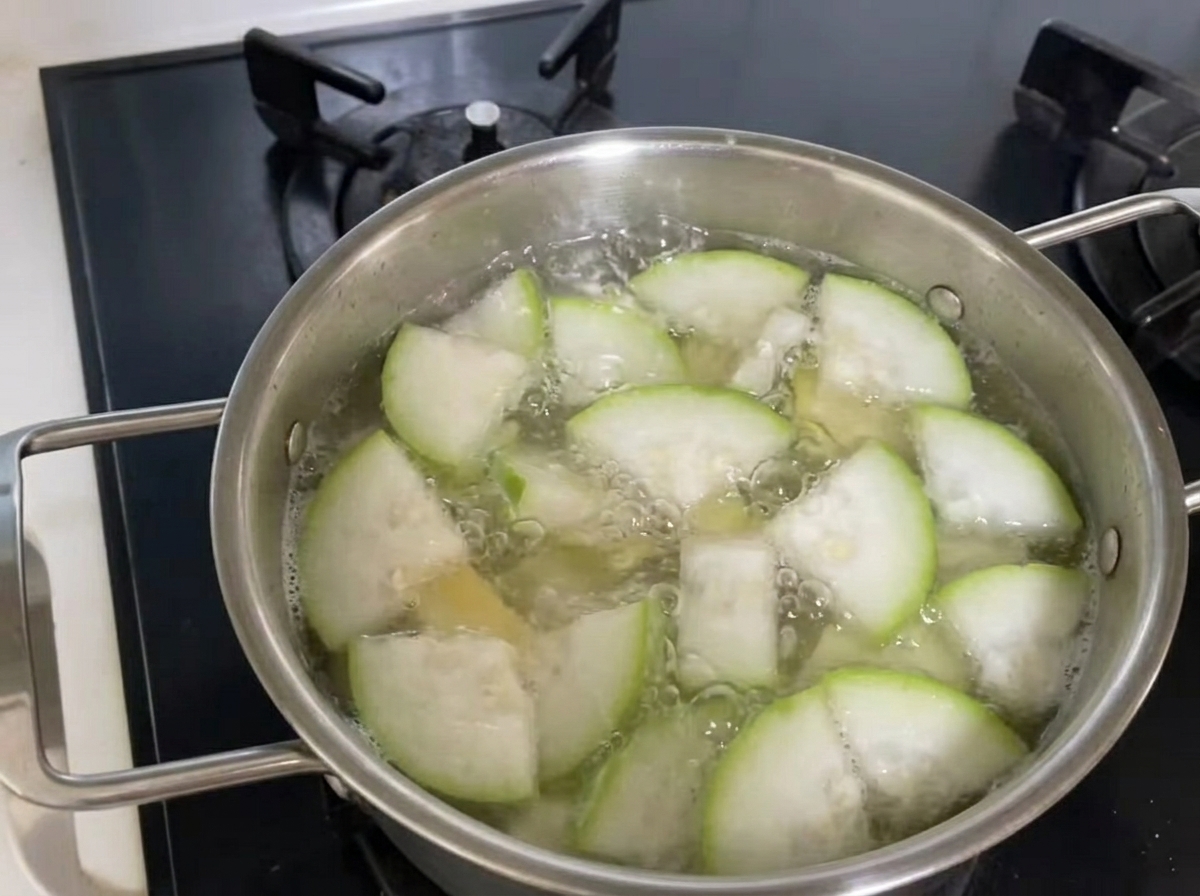 Des pinces en métal soulevant une portion de nouilles, de courgettes et de palourdes de la marmite de soupe bouillante.