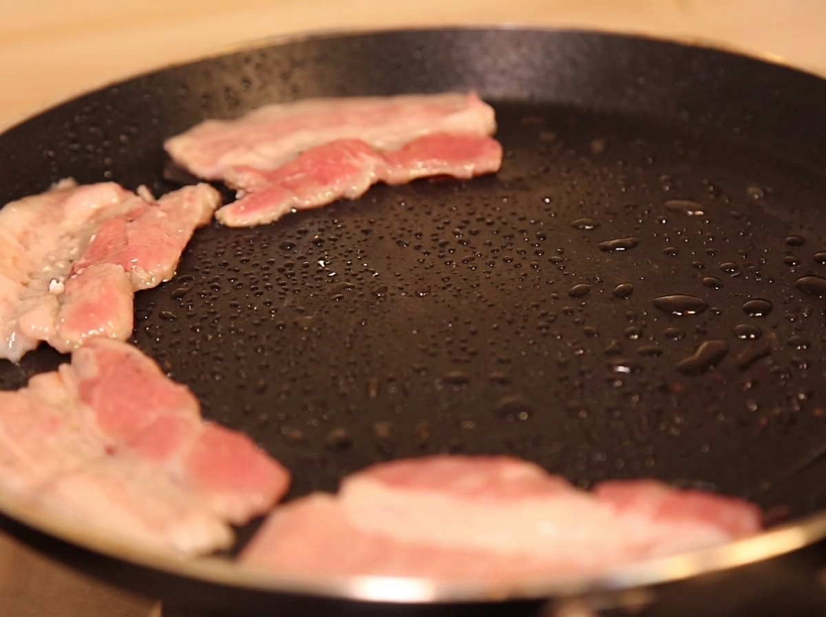 Tranches de porc dorant dans une poêle chaude avec un peu dhuile.