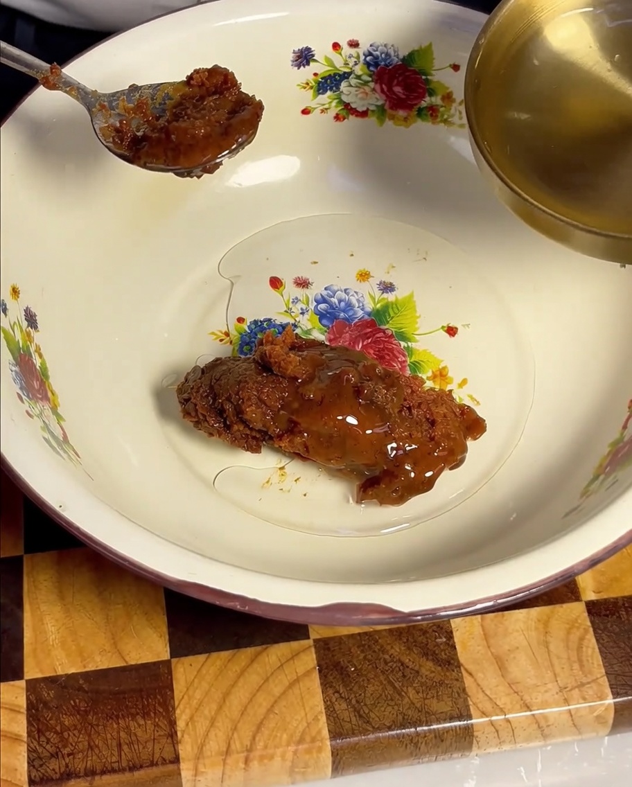 Du vin de cuisine clair est versé avec une louche dorée dans le bol contenant la pâte de soja.
