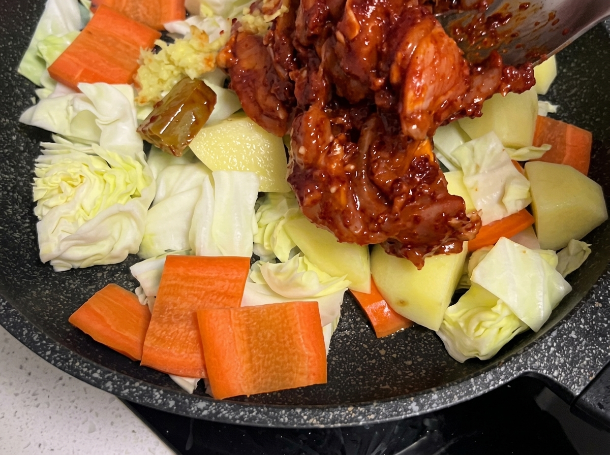 Les morceaux de poulet marinés déposés sur le lit de légumes.