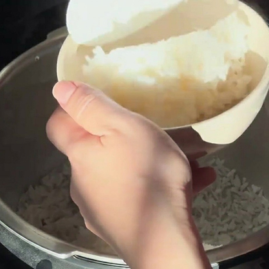 Riz blanc vapeur servi dans un bol avec une spatule.