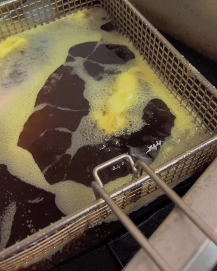 Des haricots verts en train de frire dans lhuile chaude dune friteuse.