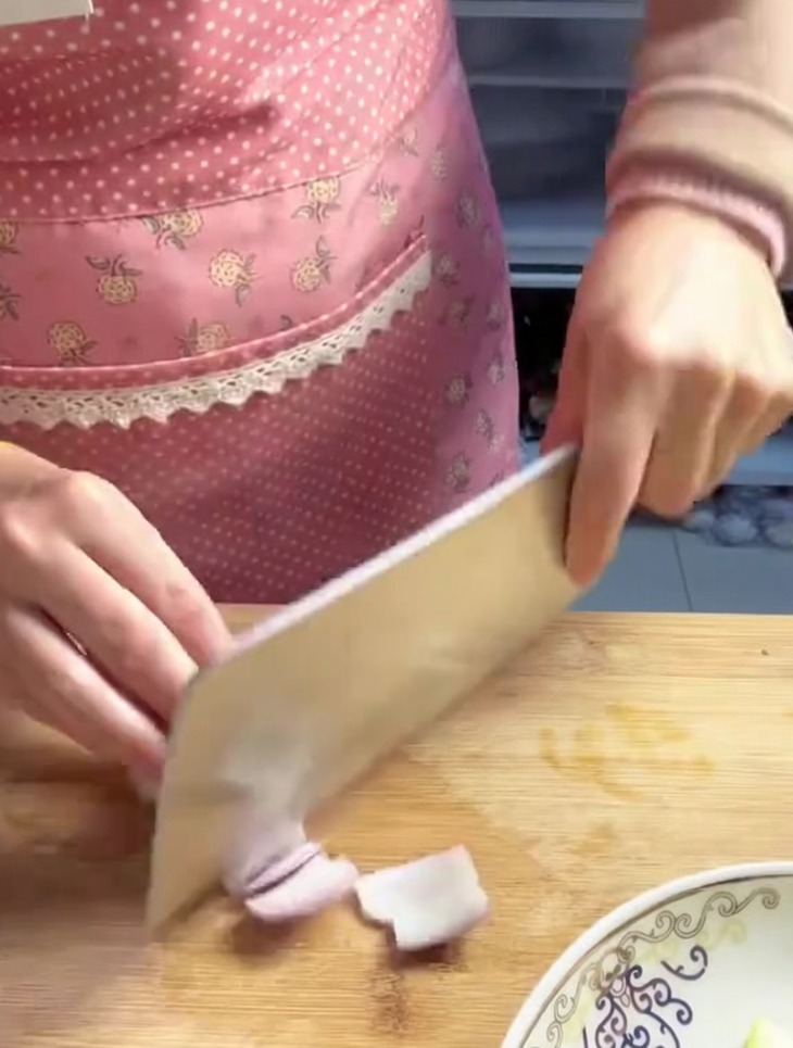 Oignon rouge grossièrement haché en morceaux de taille moyenne sur une planche à découper.