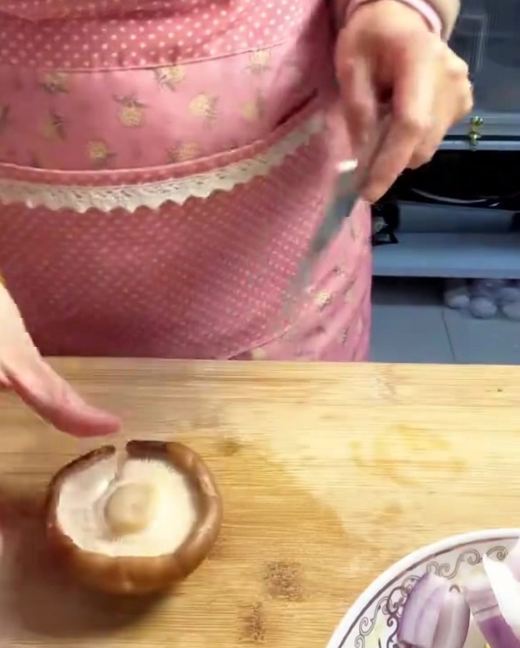 Champignons shiitake frais tranchés en lamelles uniformes sur une planche à découper en bois.