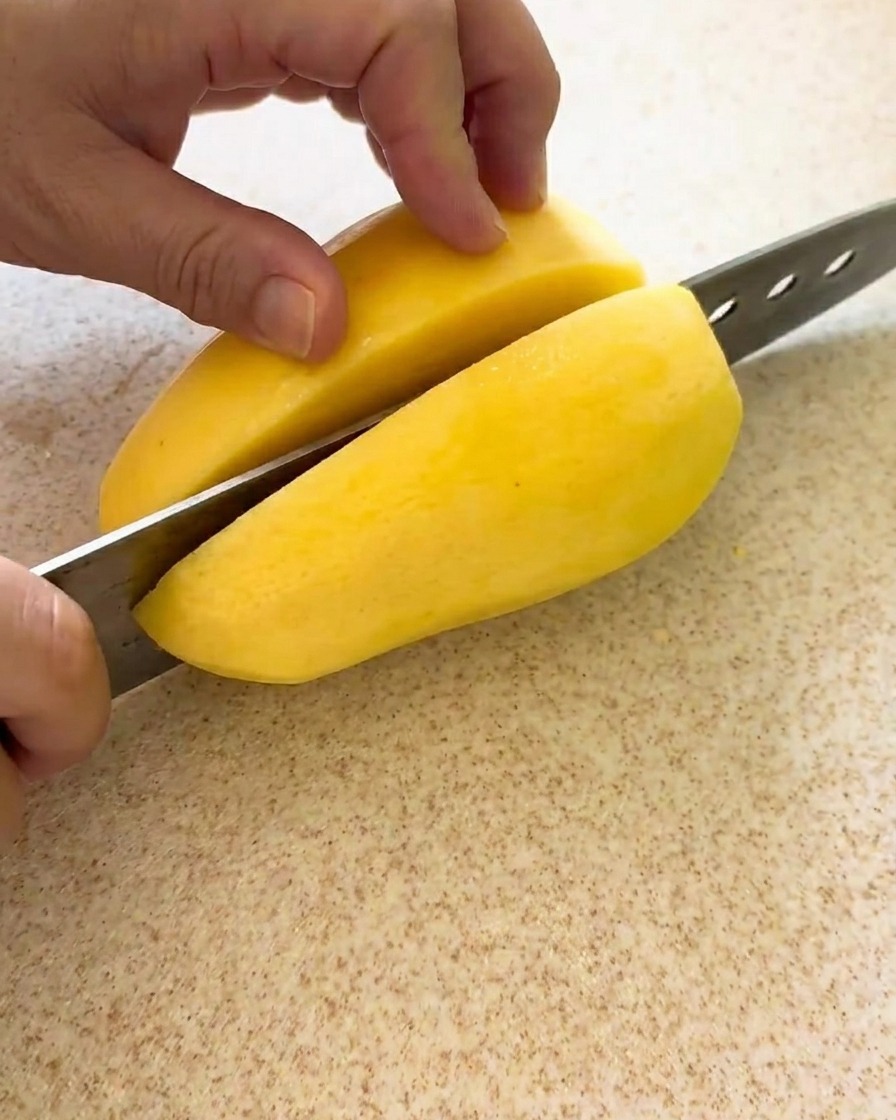 Pommes de terre coupées en cubes uniformes sur une planche à découper.