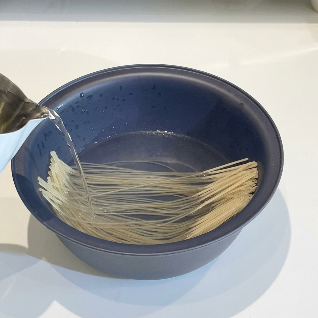 Nouilles de verre trempées dans un bol deau chaude, prêtes à être utilisées.