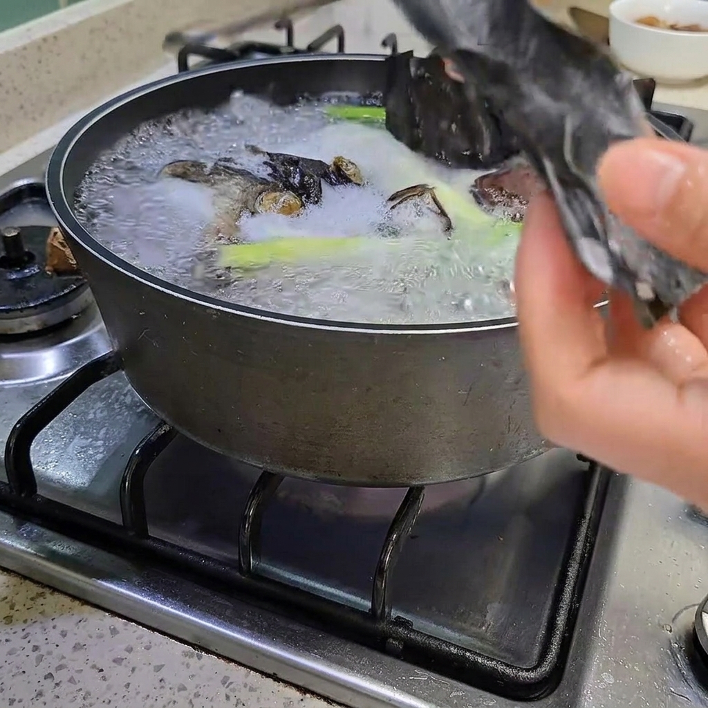 Des pinces retirant un morceau de kelp de la marmite.