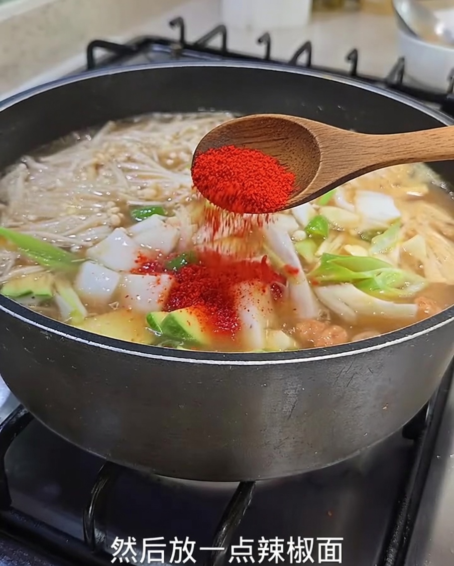 Piment rouge en poudre saupoudré sur le ragoût bouillonnant.