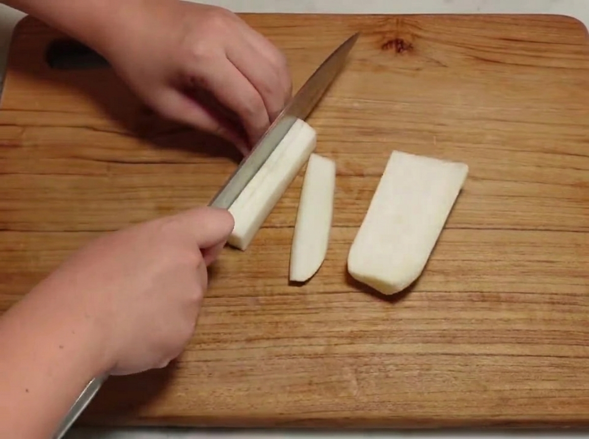 Radis blanc découpé en petits cubes sur une planche à découper en bois.