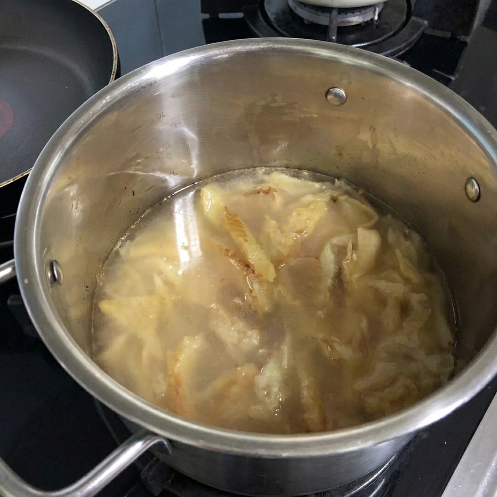 Verser de leau dans la casserole contenant le colin sauté.
