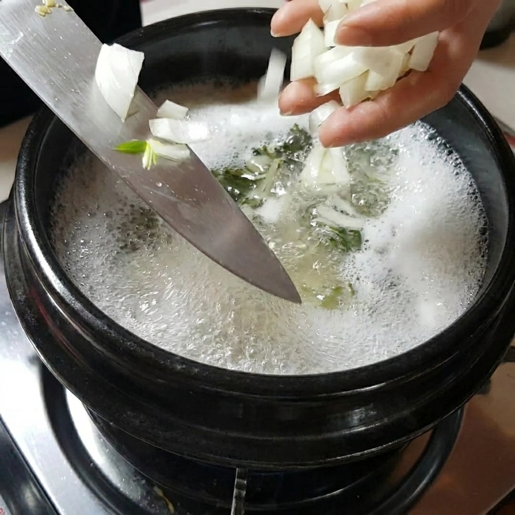 Des mains ajoutant des tranches doignons et de champignons dans la marmite de soupe frémissante.