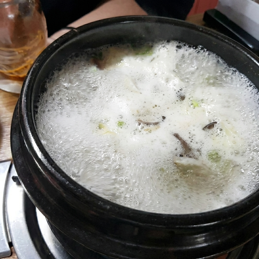 Mélange de la pâte de soja brune dans le bouillon à lintérieur du pot en pierre.