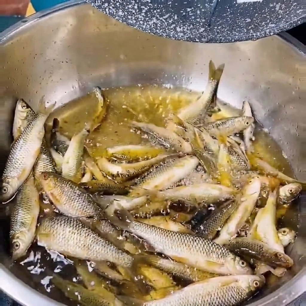 Petits poissons frais de rivière rincés dans un bol en métal rempli deau claire.
