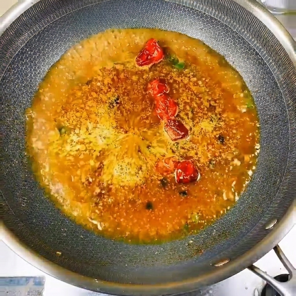 Petits poissons de rivière frais méticuleusement disposés en cercle dans le liquide de cuisson assaisonné.