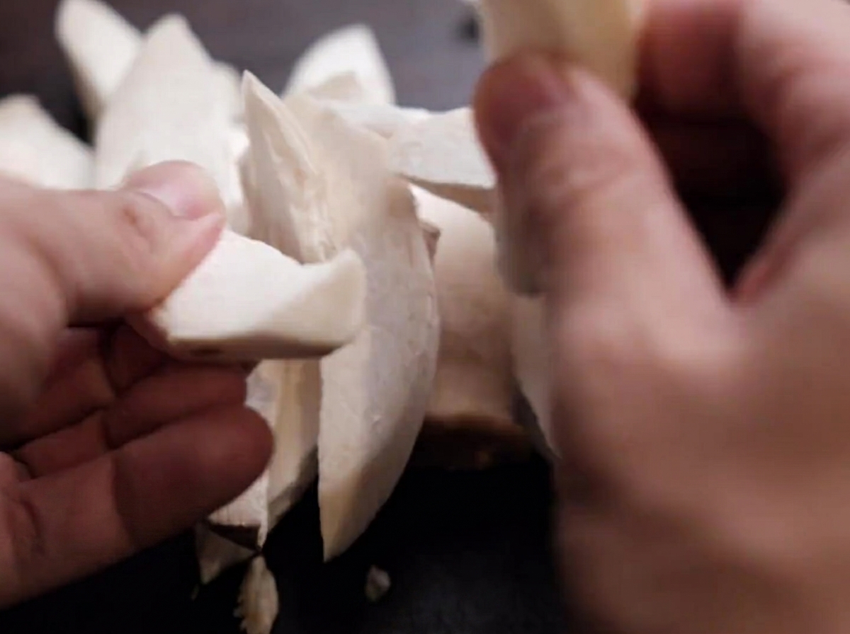 Tranches de champignons érigets déchirées à la main.
