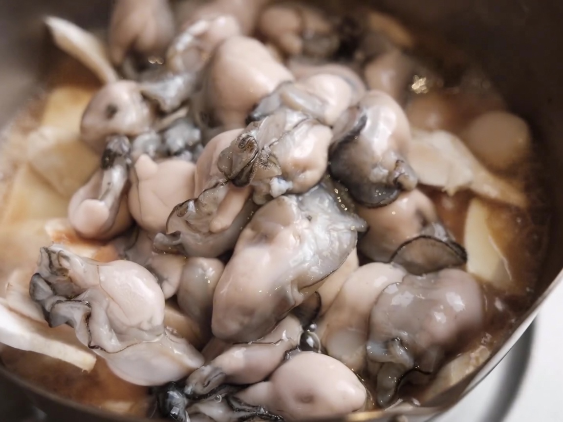 Vin de cuisine versé sur les huîtres dans la casserole.
