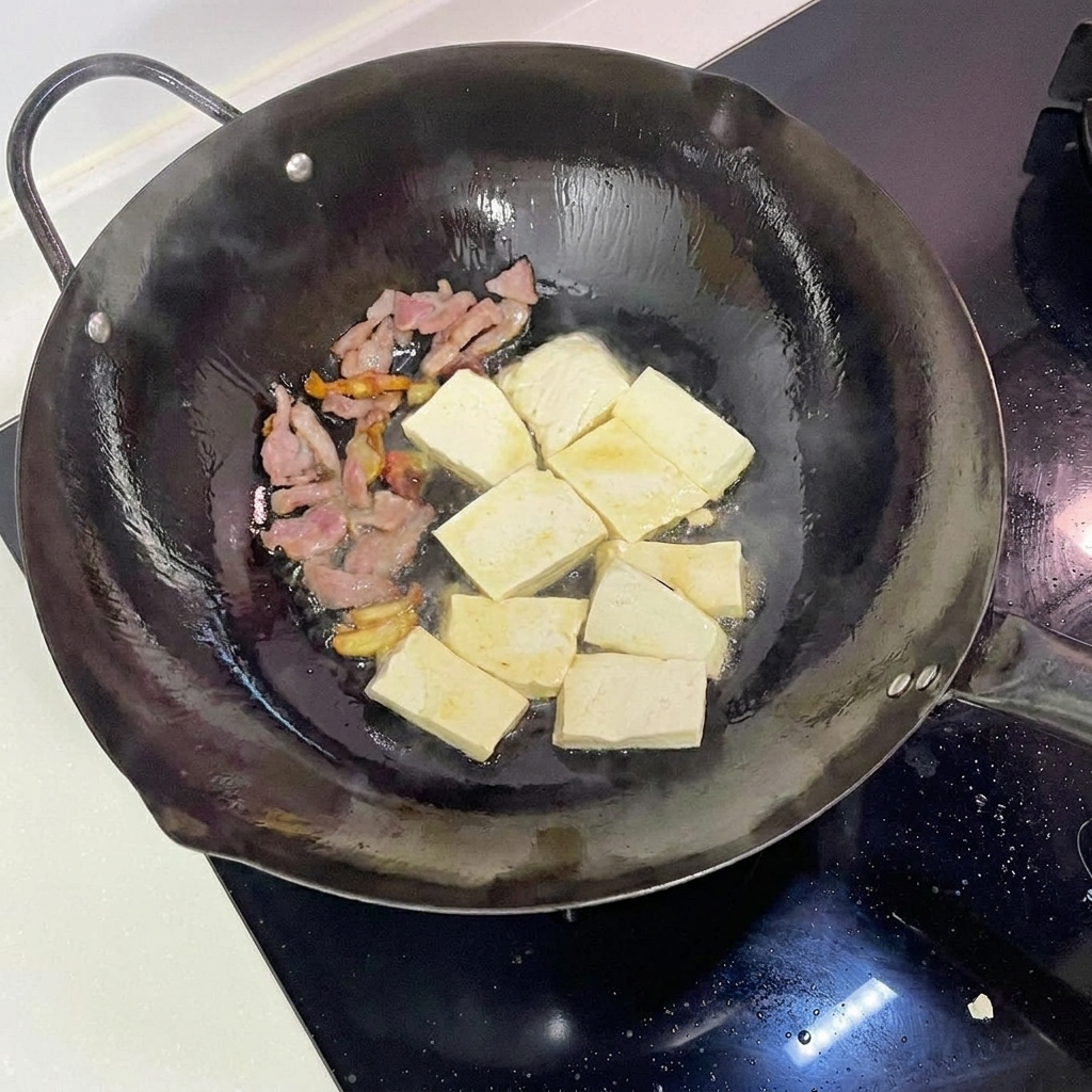 Cubes de tofu saisis dans un wok jusquà obtenir une coloration dorée.