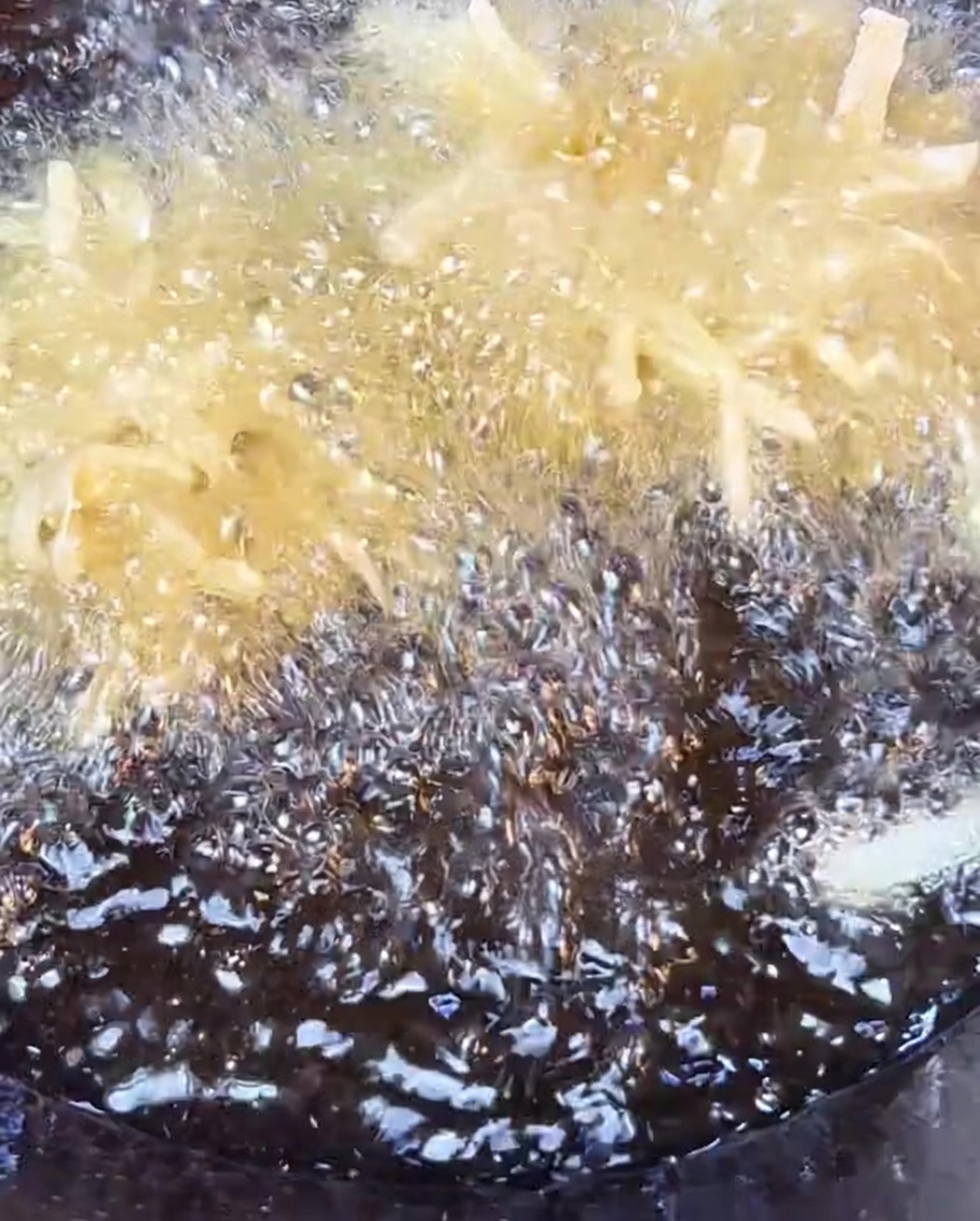 Pommes de terre râpées croustillantes en train de frire dans de lhuile chaude.