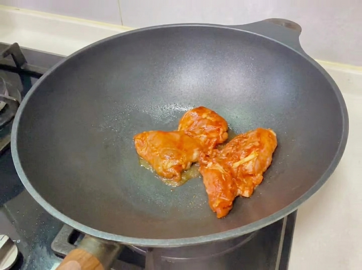 Un burger au poulet teriyaki fraîchement assemblé sur une planche en bois, prêt à être mangé.