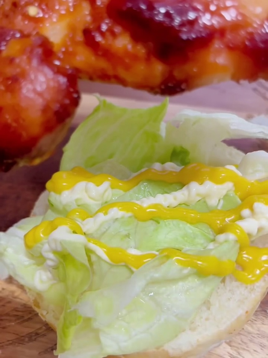 Un morceau de poulet teriyaki glacé placé sur la laitue nappée de sauce.