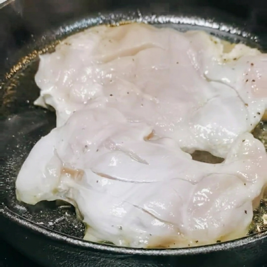 Sauce teriyaki et vin blanc versés dans la poêle sur le poulet en cours de cuisson.