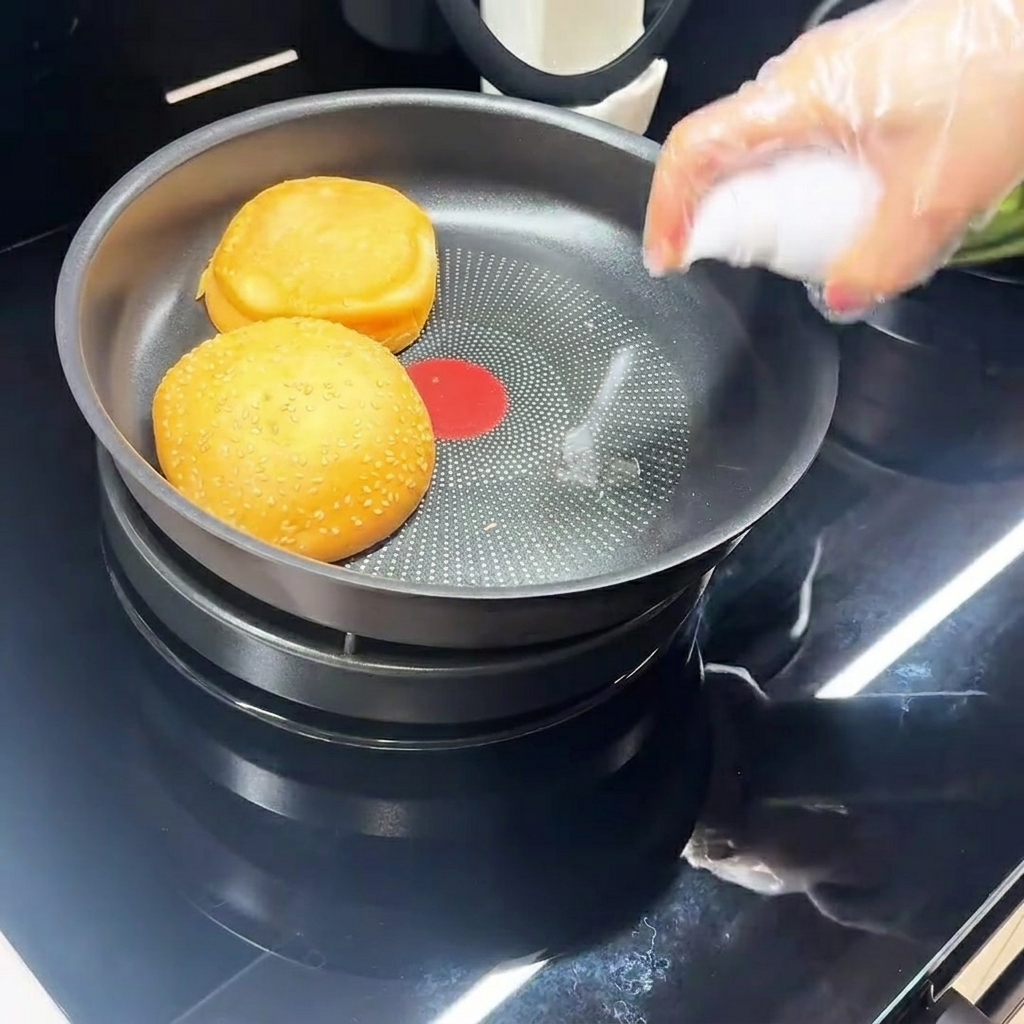 Un œuf en train de frire dans une poêle noire antiadhésive.