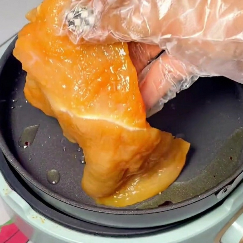 Tranches de poulet marinées en train de dorer dans une poêle chaude huilée.