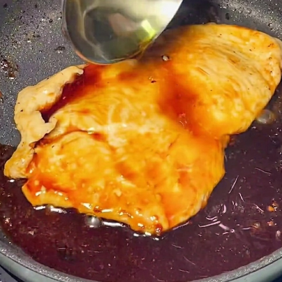 Sauce teriyaki riche et brillante versée sur le poulet doré dans une poêle.