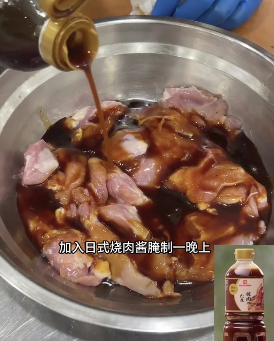 Cuisses de poulet désossées marinant dans de la sauce teriyaki japonaise dans un bol en inox.