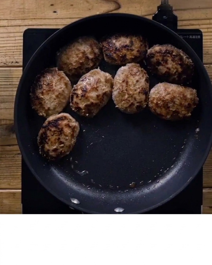 Sauce teriyaki versée sur les steaks hachés dorés dans une poêle.