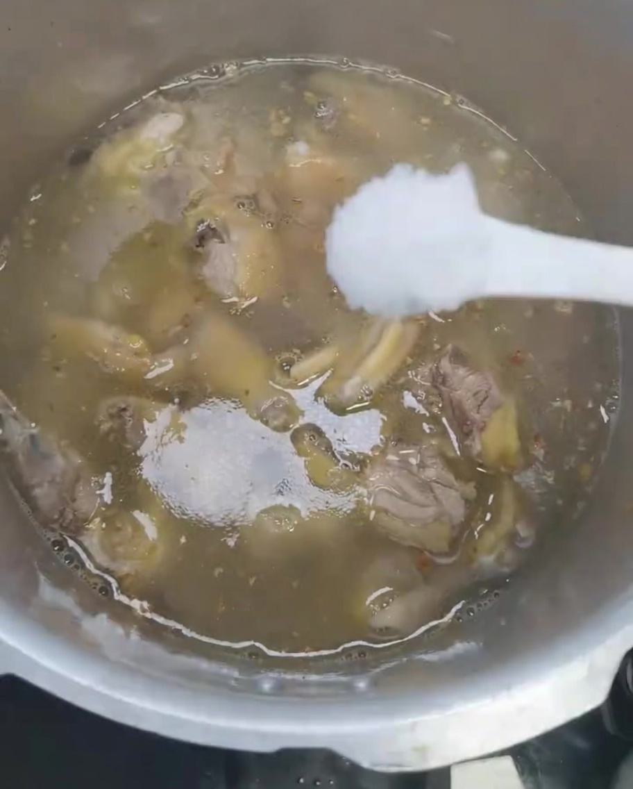 Sel ajouté à la soupe de poulet dans lautocuiseur.