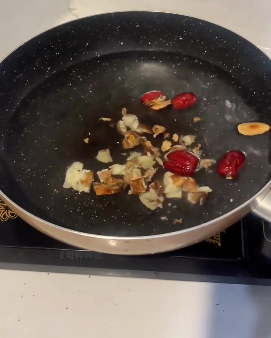 Morceaux de poulet cru ajoutés à la marmite deau froide avec le gingembre et les dattes.