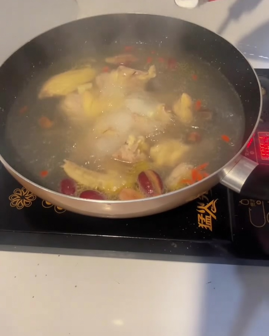 Une cuillère de sel ajoutée à la soupe au poulet bouillante pour lassaisonner.