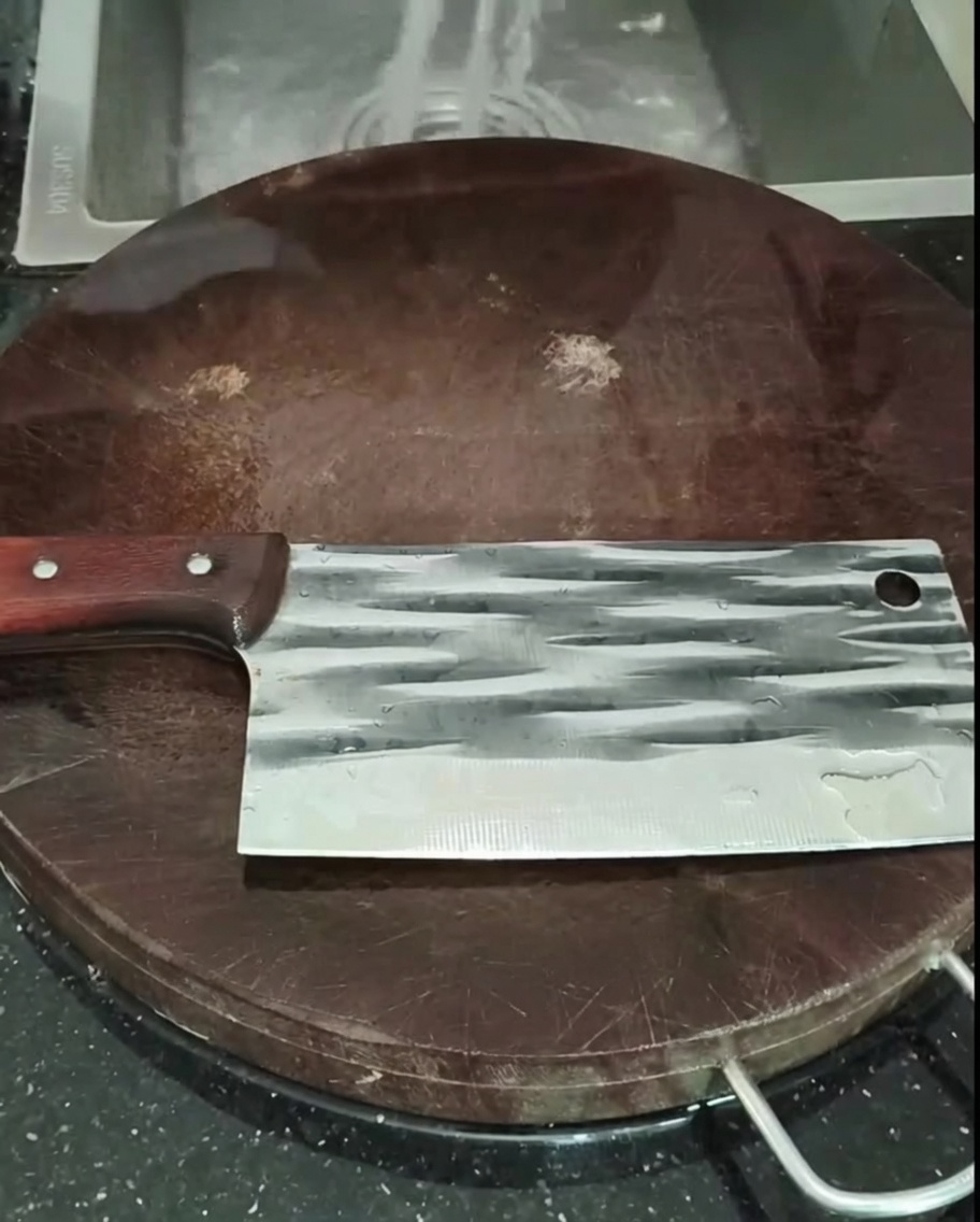 Morceaux de poulet rincés dans une passoire sous le robinet.