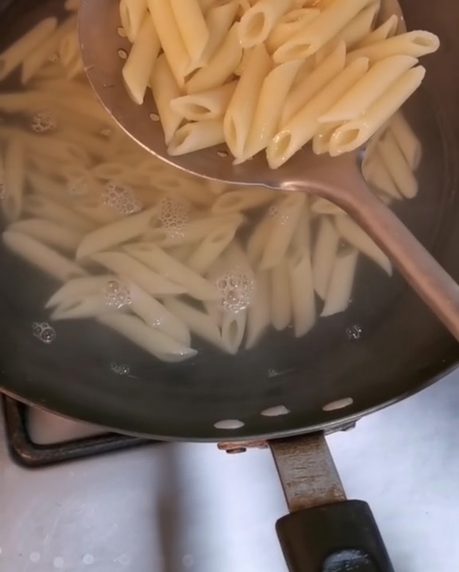 Des pennes retirées de leau bouillante à laide dune écumoire.