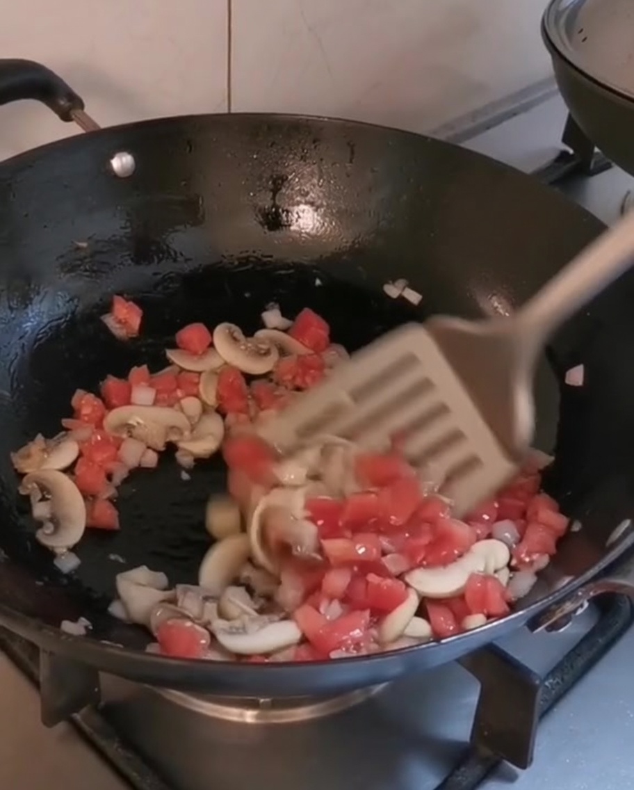 Légumes hachés et champignons cuisant dans un wok avec de lhuile dolive.